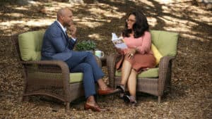 This is a photograph of Wes Moore and Oprah Winfrey sitting down, outside, for a face-to-face interview. 