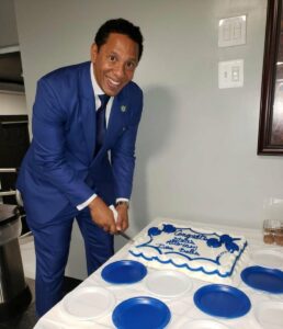This is a photograph of Baltimore City State's Attorney Ivan Bates cutting a cake. 